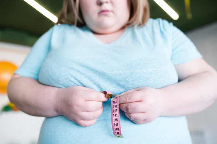 Femme obèse mesurant son tour de taille.