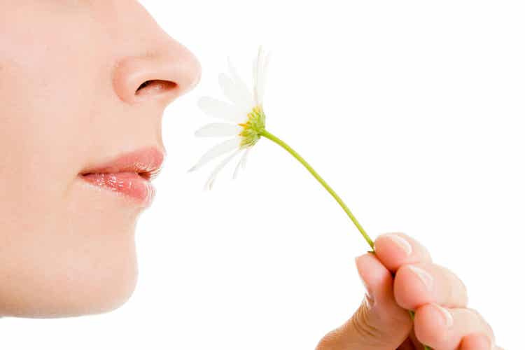 Une femme qui sent une marguerite.