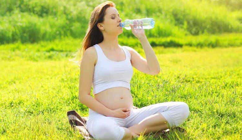 Femme enceinte qui boit de l'eau.
