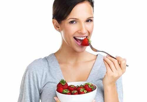 Une femme qui mange des fraises. 