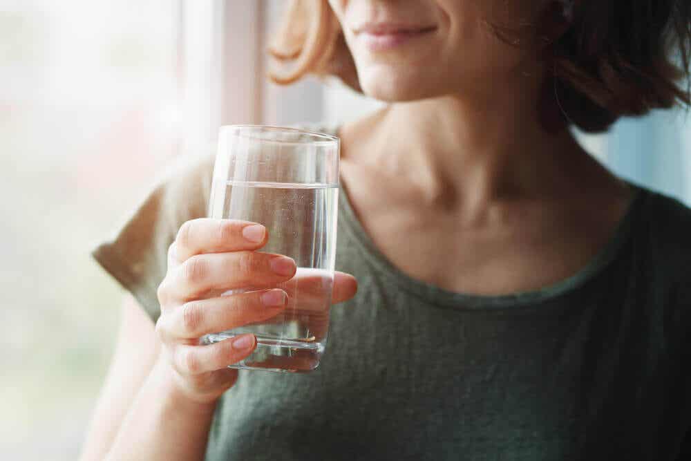 Femme qui boit un verre d'eau.