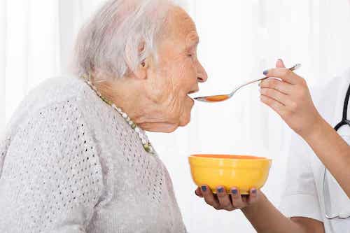 Femme âgée qui mange de la soupe.