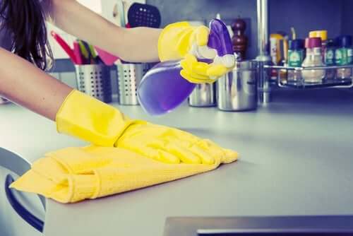 Femme qui désinfecte les surfaces.