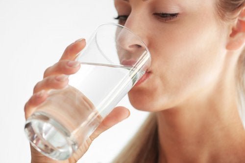 Femme qui boit un verre d'eau.