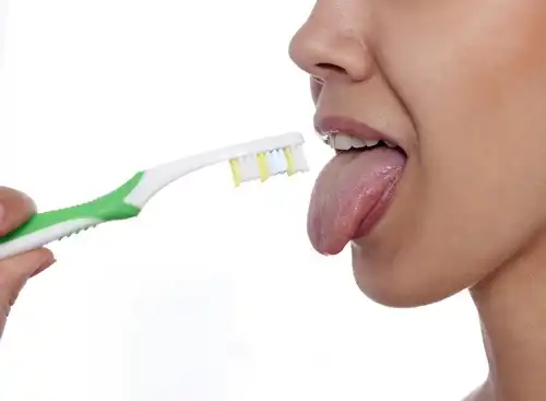 Femme qui se brosse la langue.