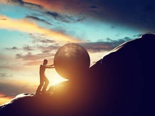 Homme qui pousse une boule sur montagne.