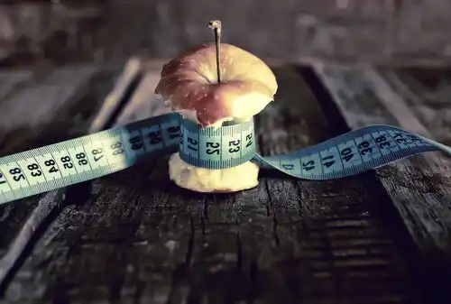 Mètre ruban enroulé autour d'un trognon de pomme.