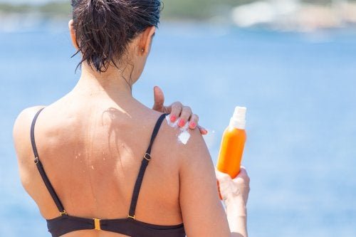 Femme qui met de la crème solaire.