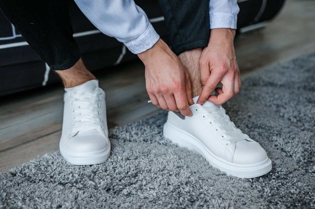 homme laçant ses baskets